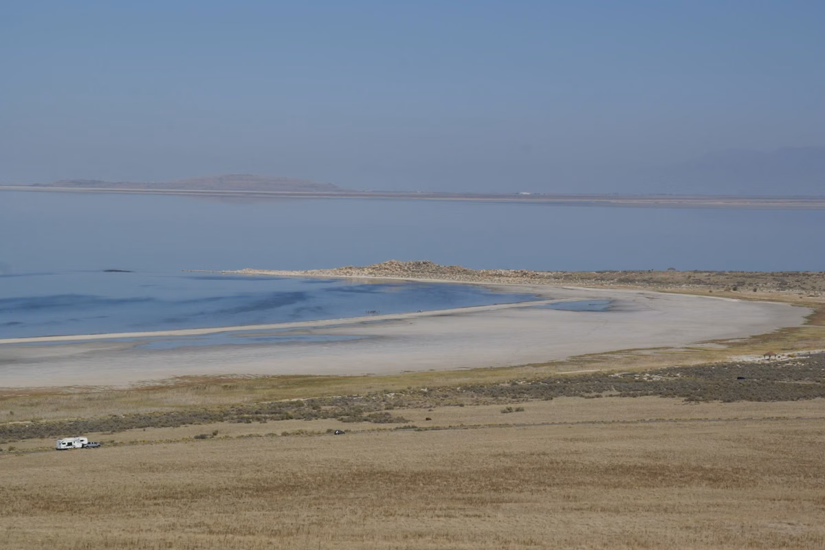 A long curving beach on Great Salt Lake seen from a hillside on Antelope Island