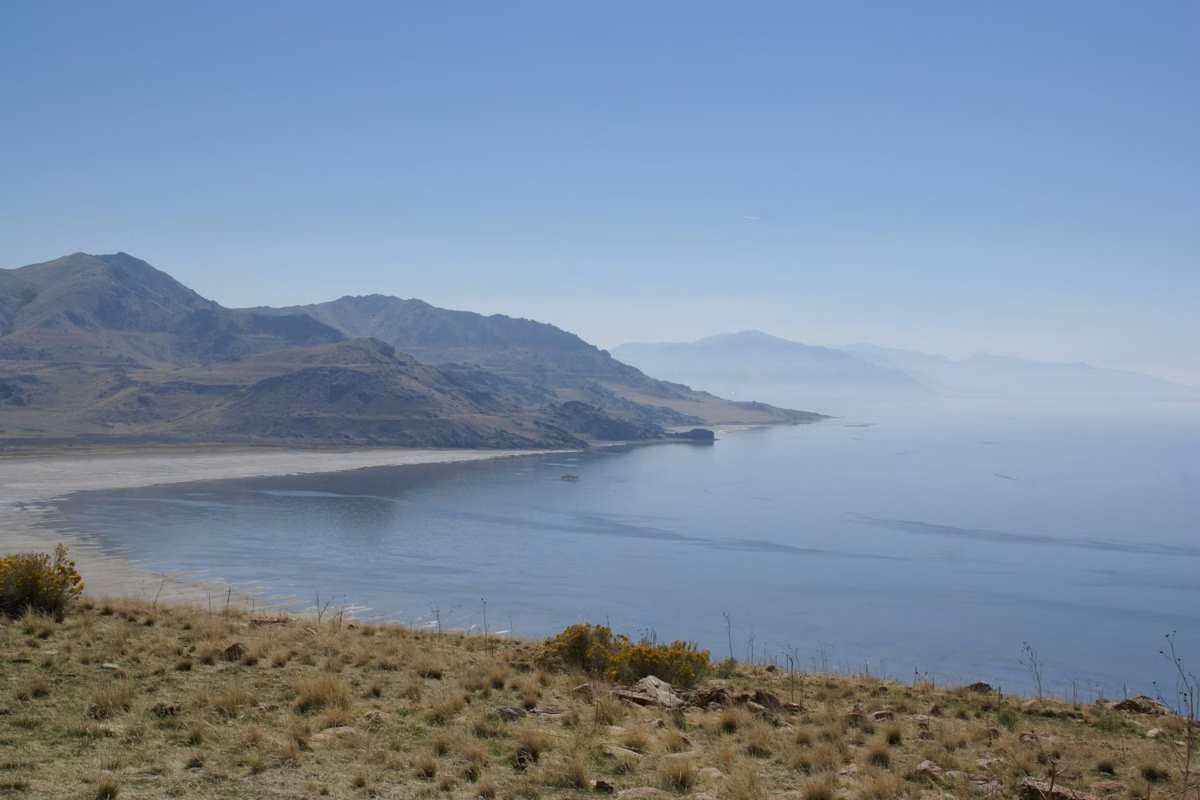 The steep slopes of Antelope Island dropping to the calm water of Great Salt Lake